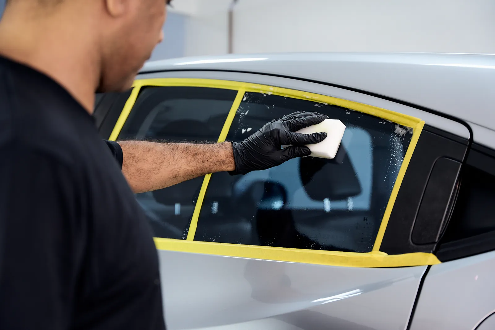 Profissional realizando o cuidado com vidro automotivo